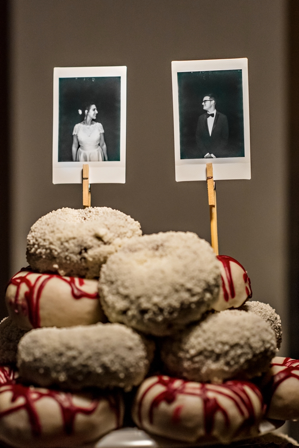 A wedding cake made of donuts from Federal Donuts and topped with polaroids of the bride and groom.